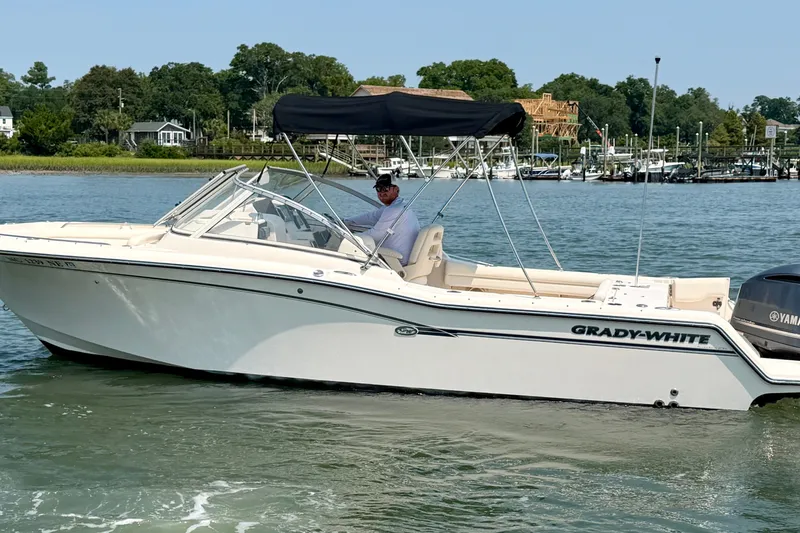 Slide: The Image of 2017 Grady-White Freedom 235 boat on calm water, featuring a sleek design and Yamaha engine. - 18