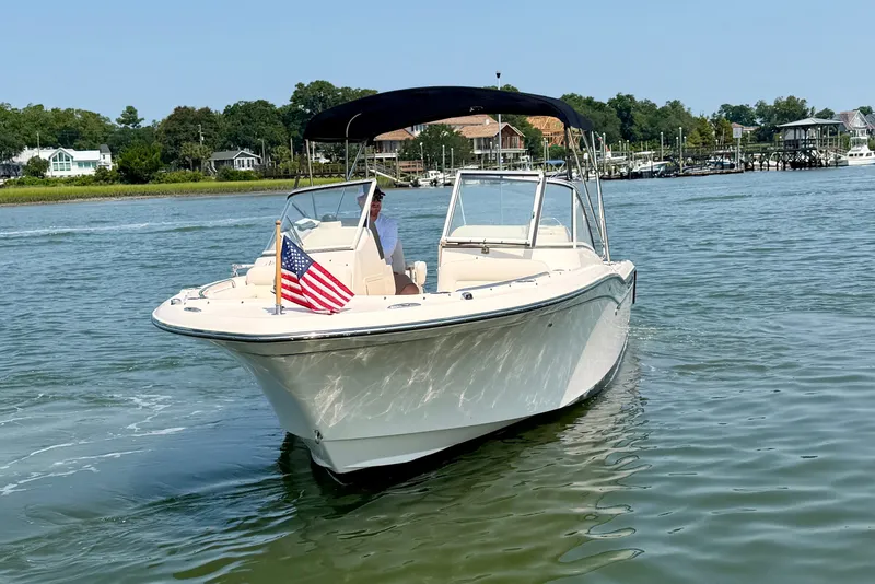 Slide: The Image of 2017 Grady-White Freedom 235 boat on water with American flag, scenic background. - 12