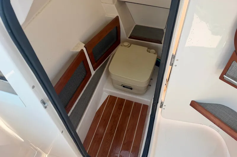 Slide: The Image of 2017 Grady-White Freedom 235 boat interior with wooden flooring and portable toilet. - 38