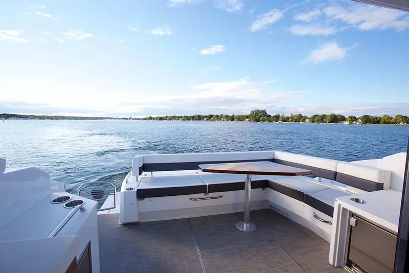 Slide: The Image of Manufacturer Provided Image: 2022 Cruisers Yachts 46 Cantius deck with seating and table, overlooking serene water. - 4