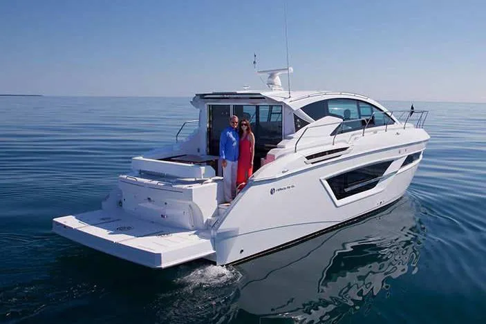 Slide: The Image of Manufacturer Provided Image: 2022 Cruisers Yachts 46 Cantius on calm water with two people on deck. - 2