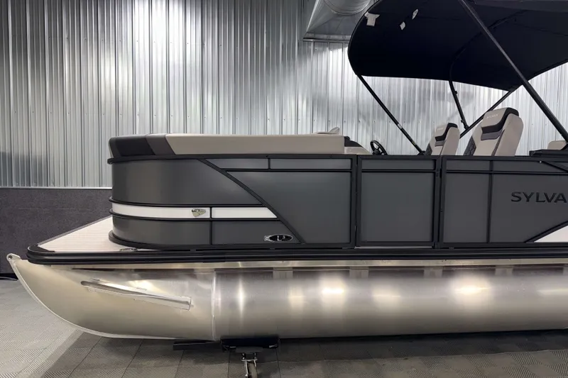 Slide: The Image of 2026 Sylvan L3 CLZ DH Tritoon boat in a showroom, featuring sleek design and modern seating. - 22