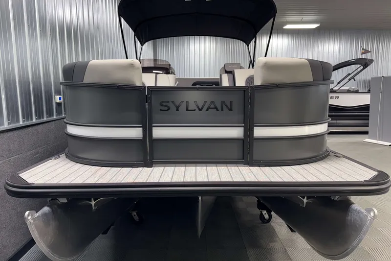 Slide: The Image of 2026 Sylvan L3 CLZ DH Tritoon boat in showroom, rear view with sleek design. - 20
