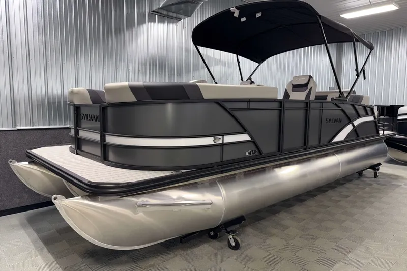Slide: The Image of 2026 Sylvan L3 CLZ DH Tritoon boat in showroom with sleek design and canopy. - 19