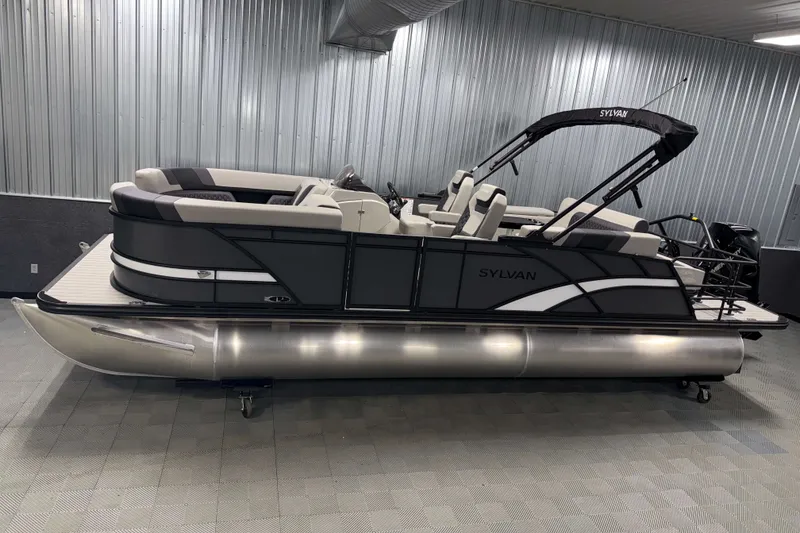 The Image of 2026 Sylvan L3 CLZ DH Tritoon boat in showroom, sleek design with modern seating. - 0