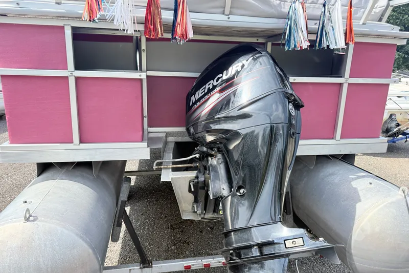 Slide: The Image of 1994 Crest 22 pontoon boat with Mercury outboard motor, pink panels, and decorative tassels. - 2
