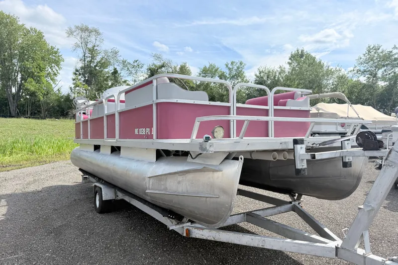 Slide: The Image of 1994 Crest 22 pontoon boat on trailer, pink and silver, parked outdoors. - 1