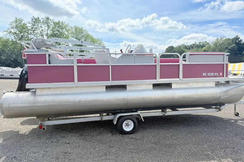 The Image of 1994 Crest 22 pontoon boat on trailer, red and silver design, parked outdoors. - 0