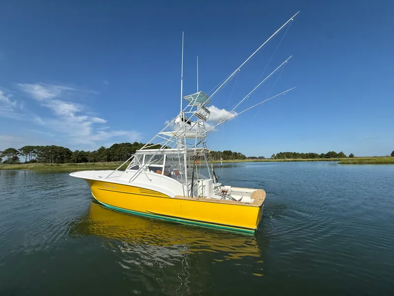 Slide: The Image of A yellow boat with a tall helm station on calm water, surrounded by trees. - 5