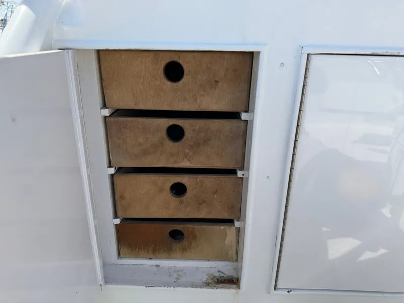Slide: The Image of A boat with four wooden drawers in a white cabinet. - 19