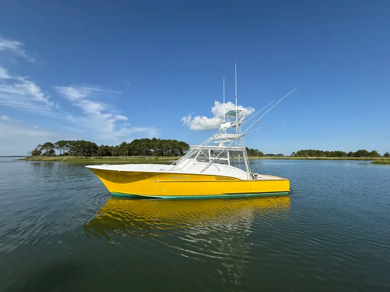 Slide: The Image of A yellow boat with a white superstructure floats on calm water under a blue sky. - 4