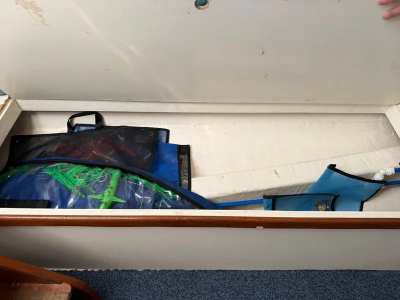 Slide: The Image of An open storage compartment on a boat reveals various gear and bags. - 32