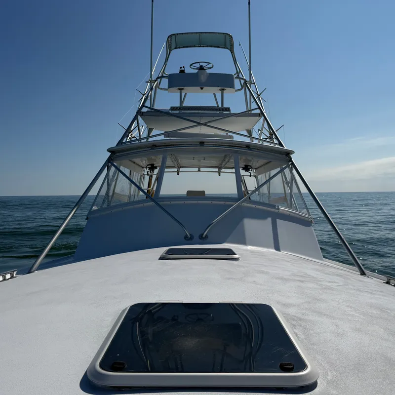 Slide: The Image of A 1993 Custom Gary Davis Carolina boat with an elevated helm station on calm waters. - 13