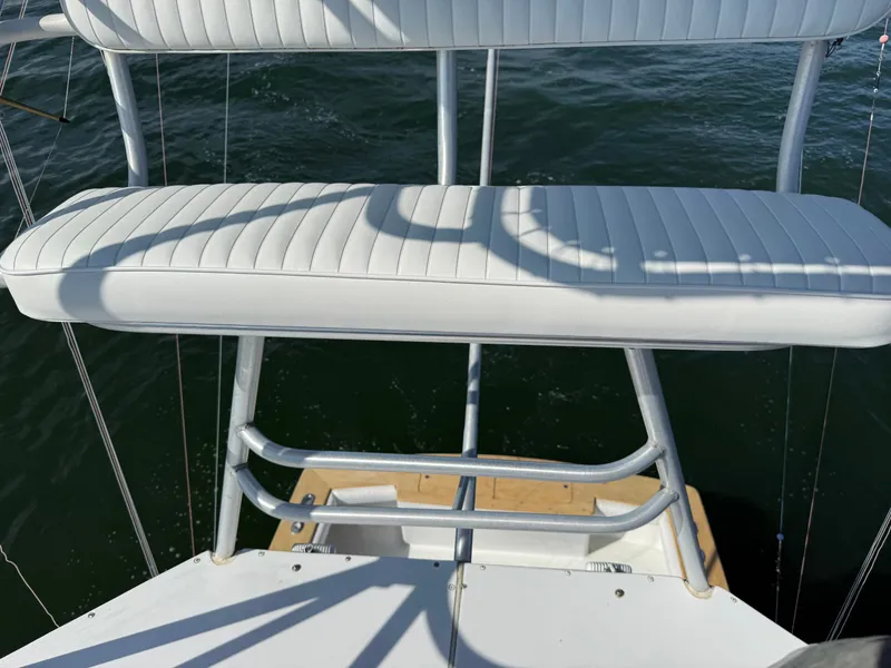 Slide: The Image of A white cushioned bench seat on a boat with a metal frame, positioned over water. - 10