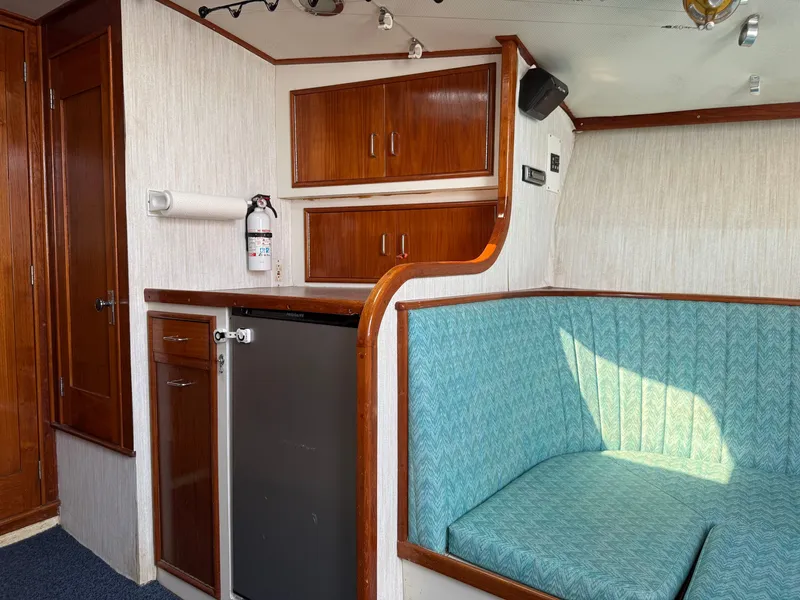 Slide: The Image of Interior of a 1993 Custom Gary Davis Carolina with wood cabinetry and a turquoise seating area. - 34