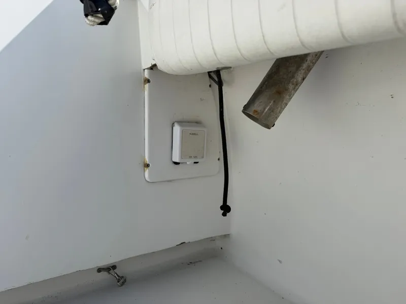 Slide: The Image of A white boat section with a small box and a pipe. Cables are visible. - 23