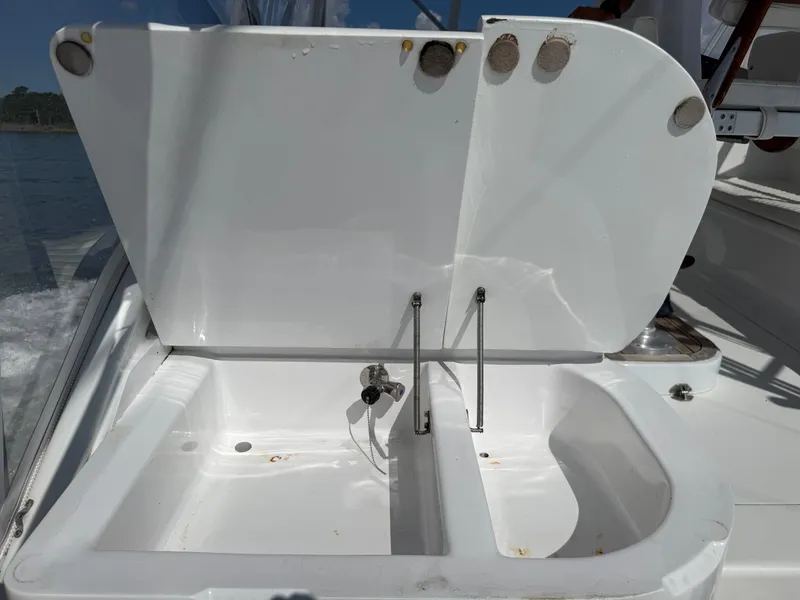 Slide: The Image of A white sink with a lifted lid on a boat, surrounded by water. - 20