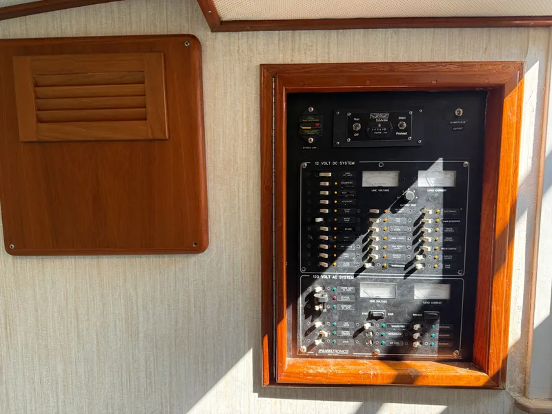 Slide: The Image of An electrical control panel on a boat with a wooden frame and a vent beside it. - 43