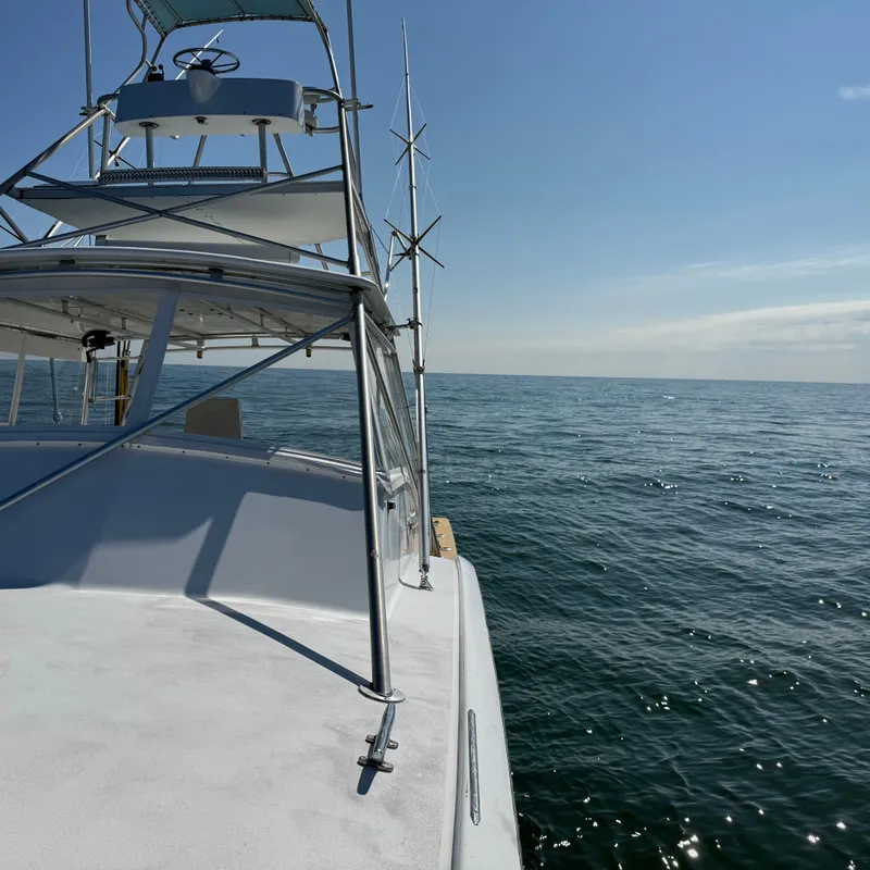 Slide: The Image of A white boat on calm water with a clear sky in the background. - 15
