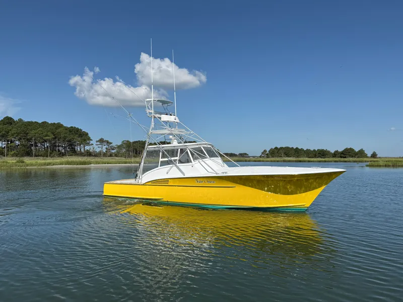 Slide: The Image of A bright yellow boat with an elevated helm cruises on calm water under a blue sky. - 2