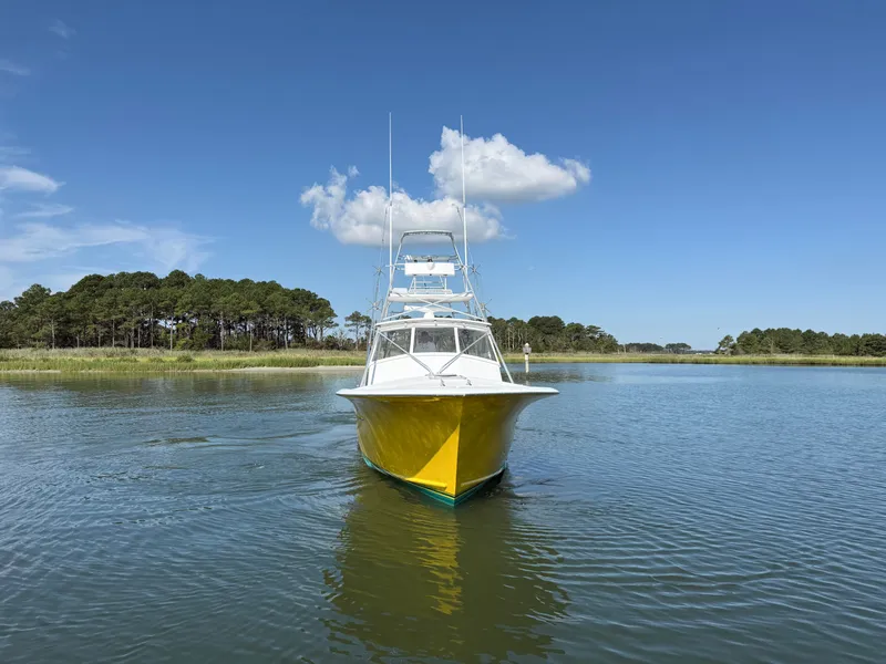 Slide: The Image of A yellow boat navigates calm waters with a wooded shoreline in the background. - 3