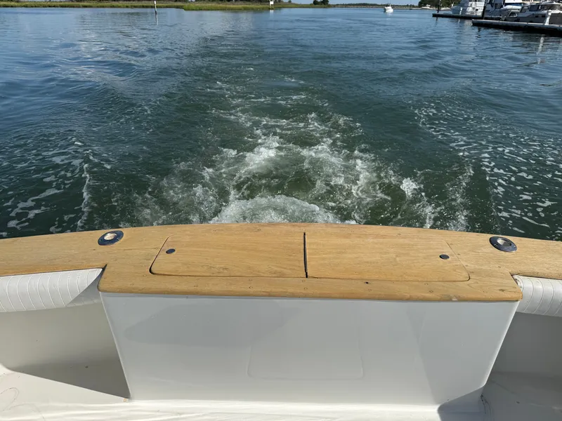 Slide: The Image of The image shows the stern of a boat with wooden trim, cruising on calm waters. - 16