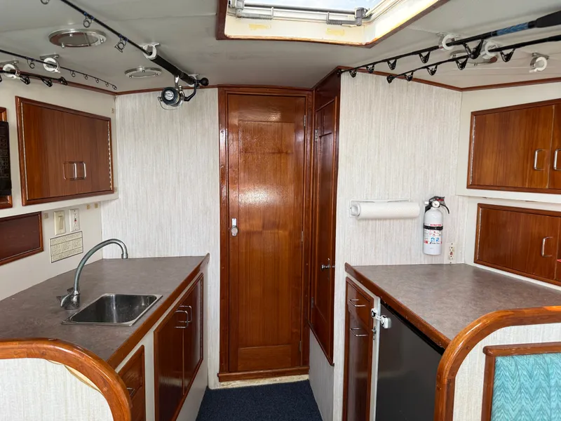 Slide: The Image of Interior of a 1993 Custom Gary Davis Carolina with wooden cabinetry and a small sink. - 30