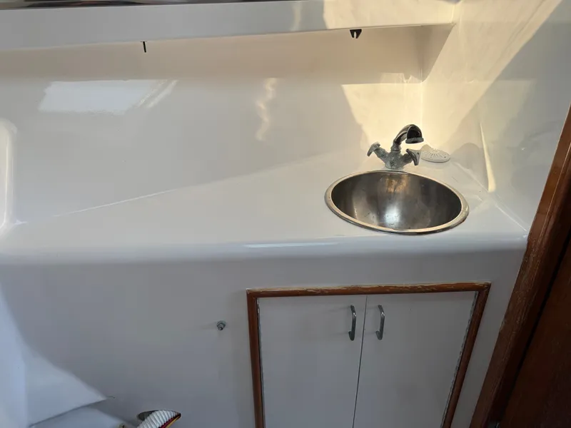 Slide: The Image of A simple sink with a faucet in a white boat bathroom. - 42