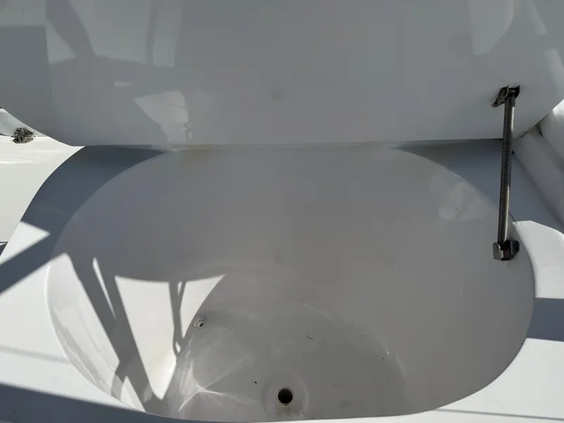 Slide: The Image of An open white storage compartment on a boat with a metal arm supporting the lid. - 21