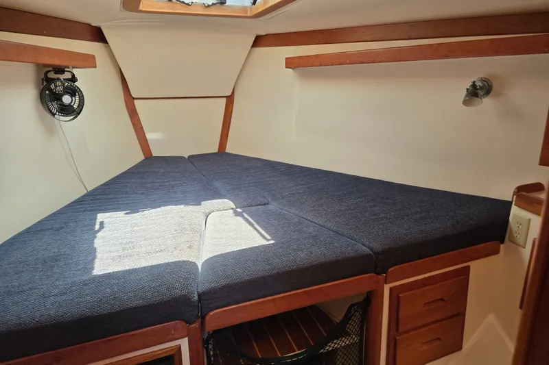 Slide: The Image of Cozy cabin interior of 2005 Tartan 3700 sailboat with blue cushions and wooden accents. - 42