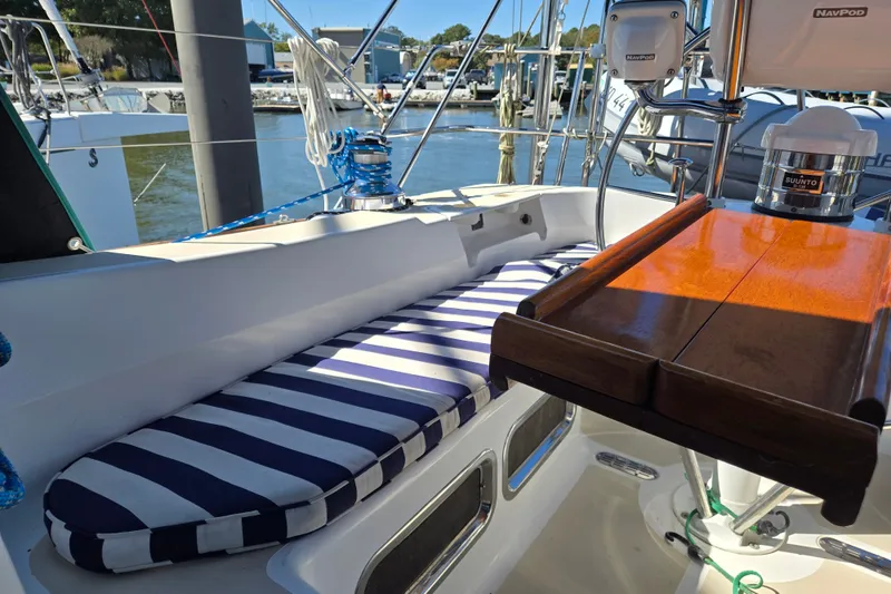Slide: The Image of Cockpit of 2005 Tartan 3700 sailboat with striped cushions and wooden table. - 13
