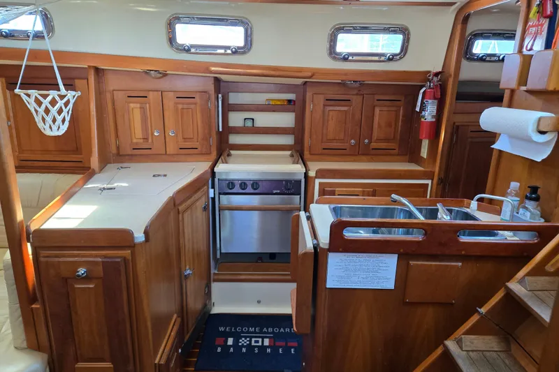 Slide: The Image of Interior of 2005 Tartan 3700 sailboat kitchen with wooden cabinetry and stainless steel appliances. - 32