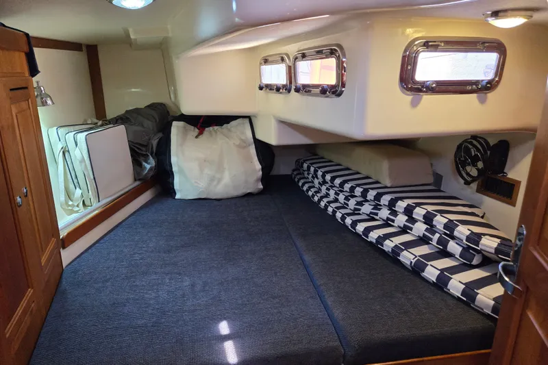Slide: The Image of Interior cabin of a 2005 Tartan 3700 sailboat with striped cushions and storage. - 37