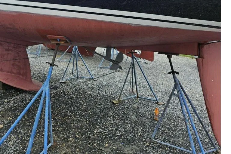 Slide: The Image of Tartan 3700 sailboat from 2005 on stands, showing hull and propeller. - 56