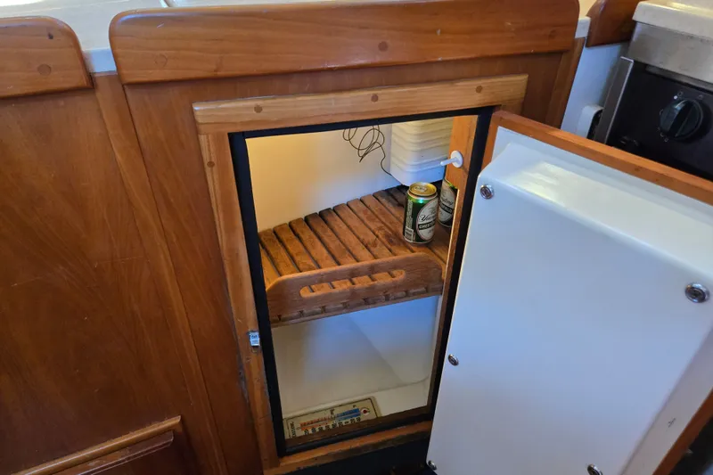 Slide: The Image of Wooden interior of a 2005 Tartan 3700 yacht with an open fridge containing drinks. - 33