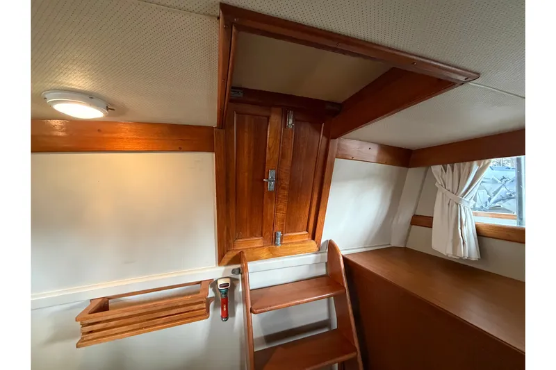 Slide: The Image of Interior of 1969 Grand Banks 42 Classic yacht with wooden stairs and window. - 43