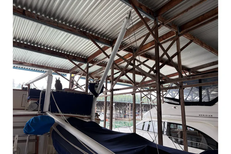 Slide: The Image of 1969 Grand Banks 42 Classic yacht in covered marina, showcasing wooden structure and nearby boats. - 17