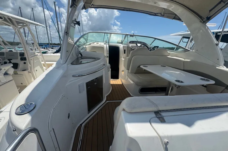 Slide: The Image of 2008 Chaparral Signature 290 boat interior with seating and table, docked under a sunny sky. - 13