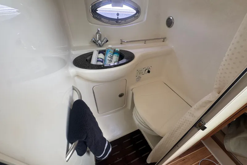 Slide: The Image of 2008 Chaparral Signature 290 bathroom with sink, toilet, and porthole window. - 33