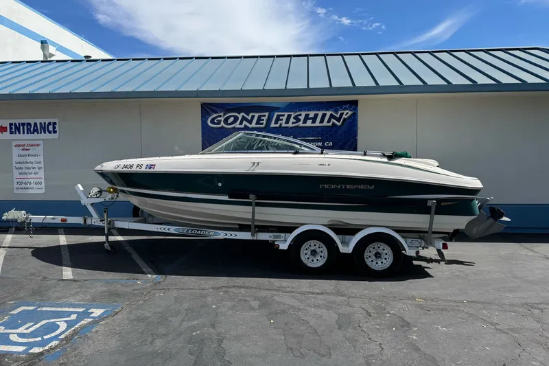 The Image of 2000 Monterey 190LS Montura boat on trailer outside a fishing store. - 1