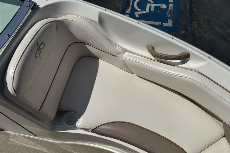 Slide: The Image of Interior seating of a 2000 Monterey 190LS Montura boat, featuring beige upholstery and armrest. - 13