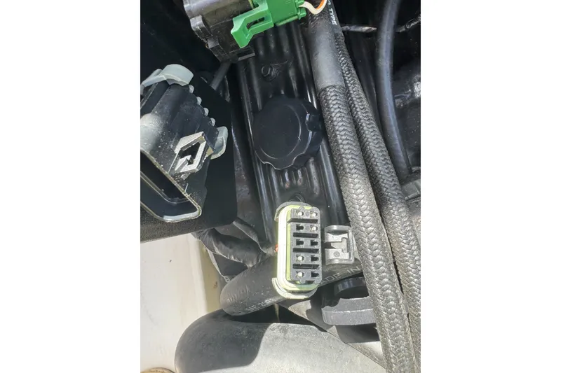 Slide: The Image of Engine components of a 2000 Monterey 190LS Montura boat, featuring connectors and cables. - 11