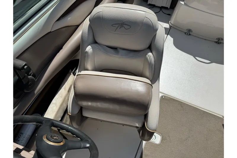 Slide: The Image of Captain's seat of a 2000 Monterey 190LS Montura boat, featuring beige upholstery. - 16