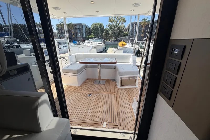 Slide: The Image of Azimut Fly 50 yacht interior, featuring elegant seating and a marina view. - 16