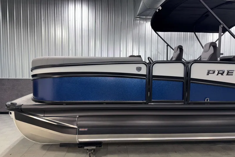 Slide: The Image of 2026 Premier 230 Solaris RF Tritoon with sleek blue and silver design in showroom. - 30