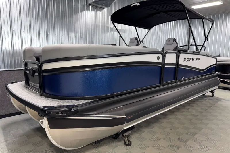 Slide: The Image of 2026 Premier 230 Solaris RF Tritoon boat with blue and white exterior in showroom. - 28