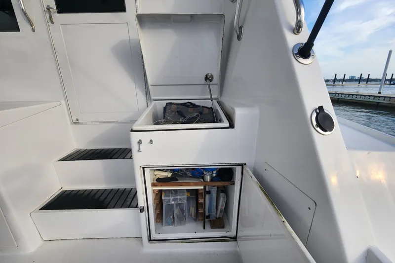 Slide: The Image of Storage compartment on a 1999 Hatteras 65 Convertible yacht, featuring organized fishing gear. - 69
