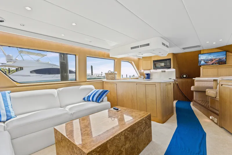 Slide: The Image of Luxurious interior of 1999 Hatteras 65 Convertible yacht with modern furnishings and large windows. - 106
