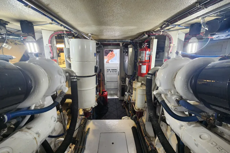 Slide: The Image of Engine room of a 1999 Hatteras 65 Convertible yacht, showcasing machinery and equipment. - 88