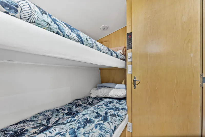 Slide: The Image of Bunk beds with floral bedding in 1999 Hatteras 65 Convertible yacht cabin. - 97